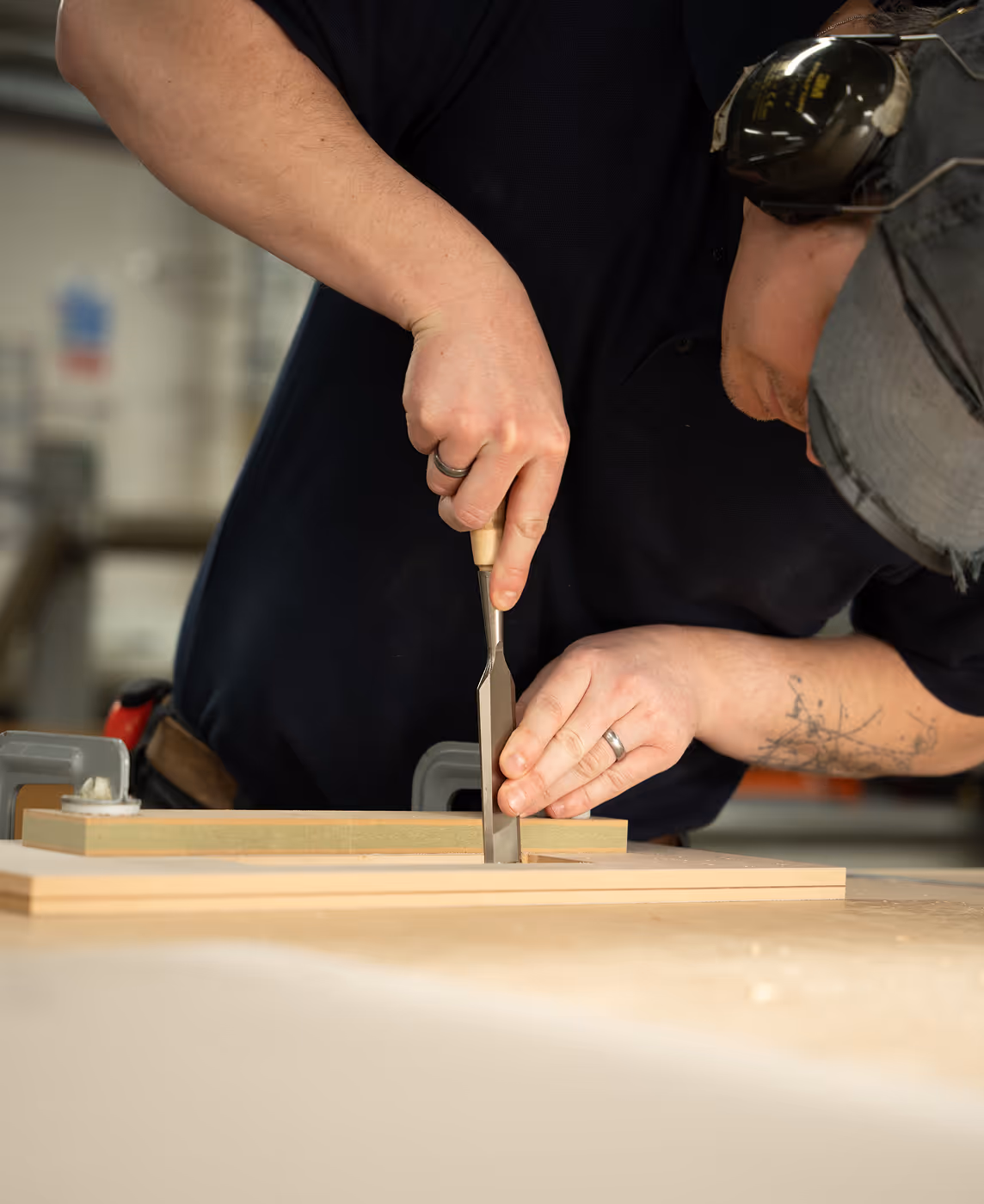 A man is working on a wooden object with a pair of scissors.