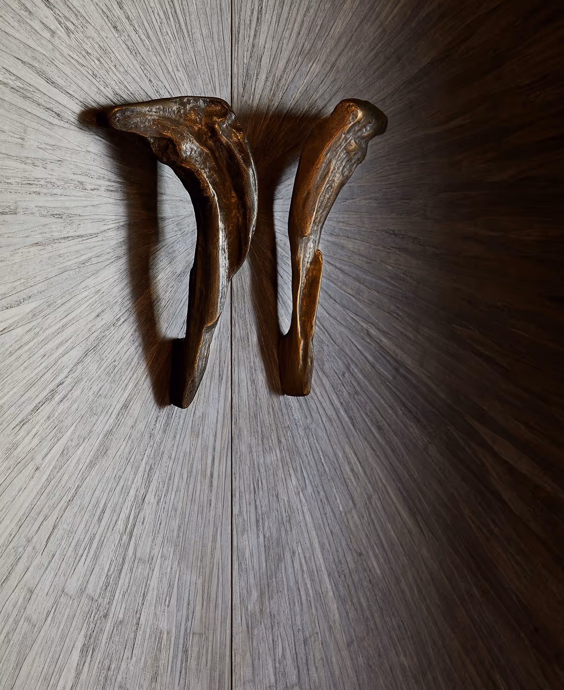 A wooden door with two wooden handles.