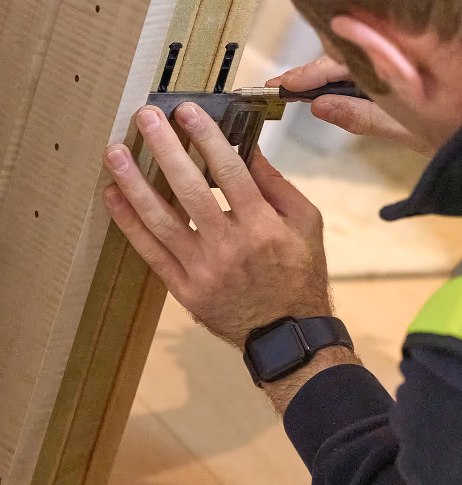 A man working on a wooden piece of furniture.