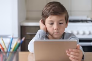 Boy watching video on electronic tablet