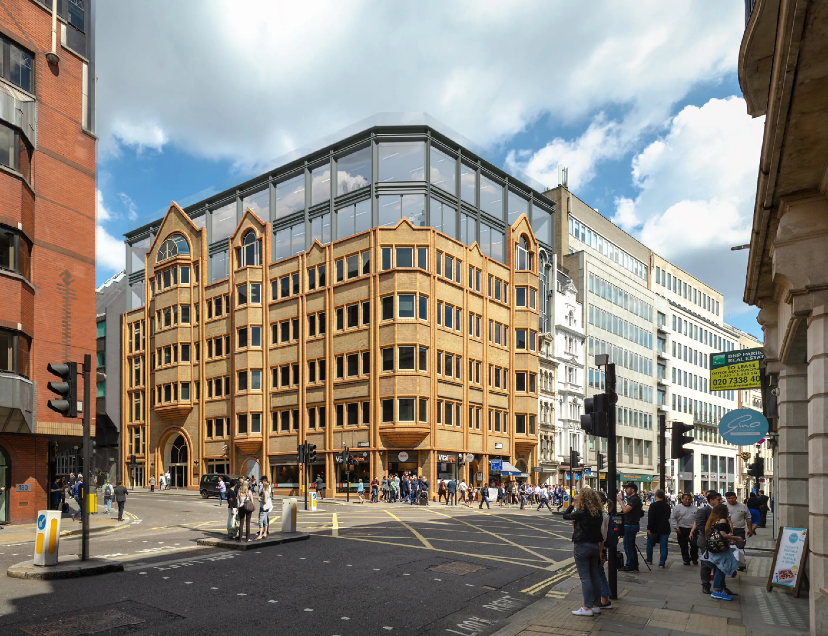 Radiance Visual. Busy street intersection with a large brick building featuring a modern glass rooftop and pedestrians crossing the road on a sunny day.