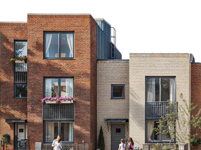 Radiance Visual. Modern multi-story residential building with red and beige brick facades, people walking in front.