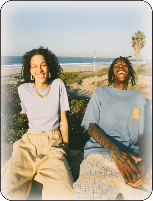 A couple of people sitting next to each other on a beach.
