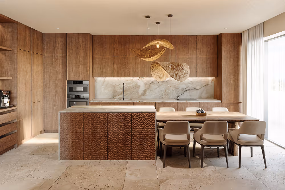 Modern kitchen with wooden cabinetry and marble backsplash featuring a central island and dining table with six beige chairs under decorative pendant lights.