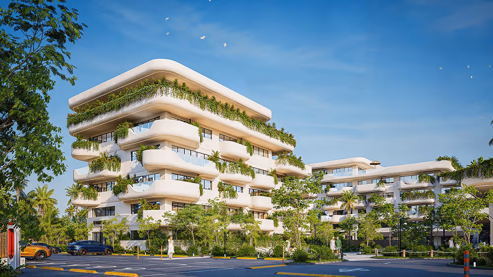 Modern white multi-story building with curved balconies adorned with green plants under a clear blue sky.