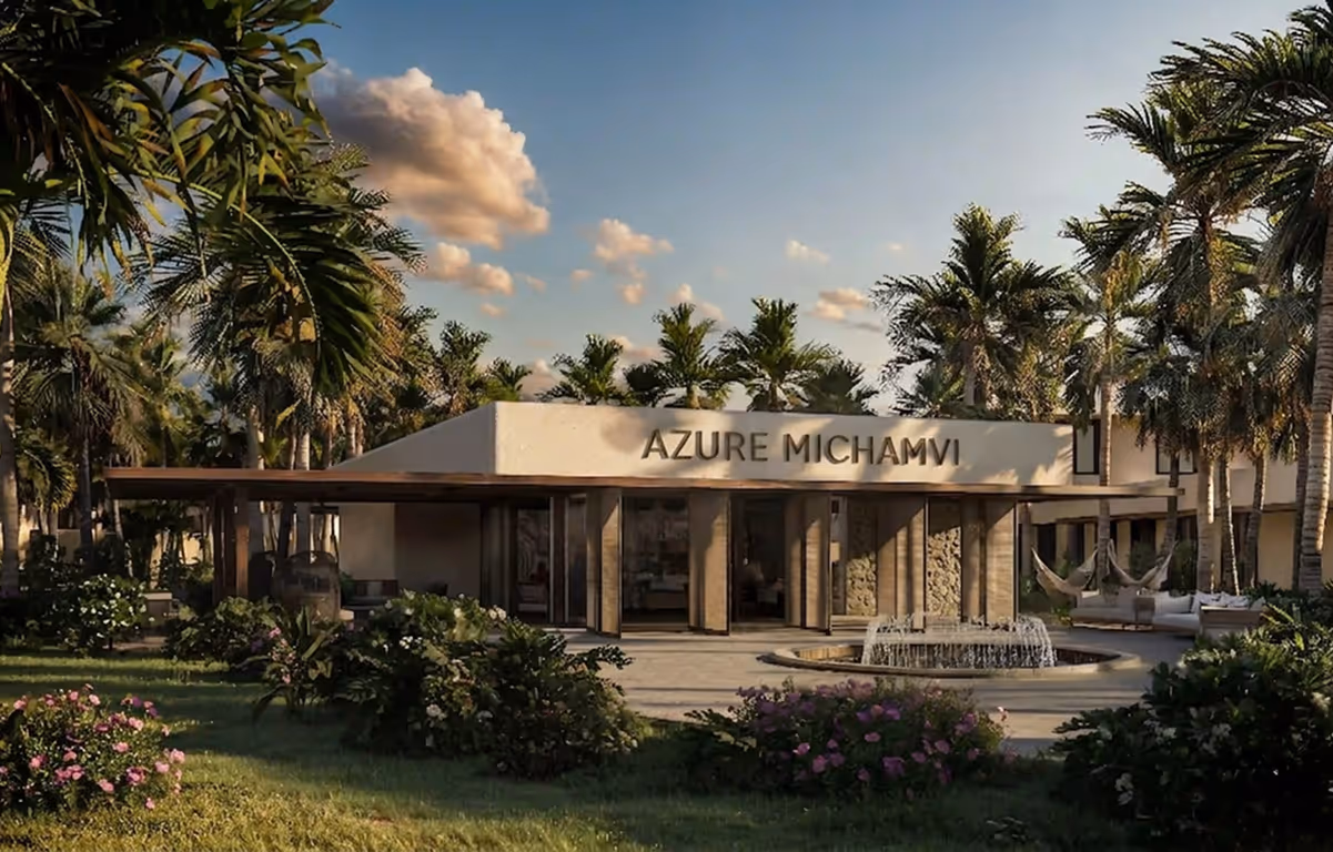 Modern residence building surrounded by palm trees and lush greenery with a central water fountain in front.
