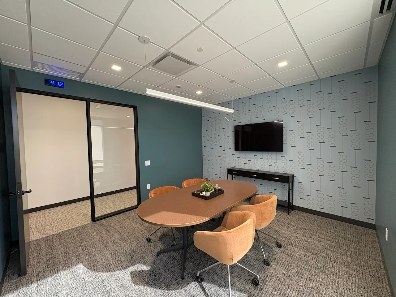 Collaborative office space with modern glass doors and natural lighting constructed by Oswald Company.