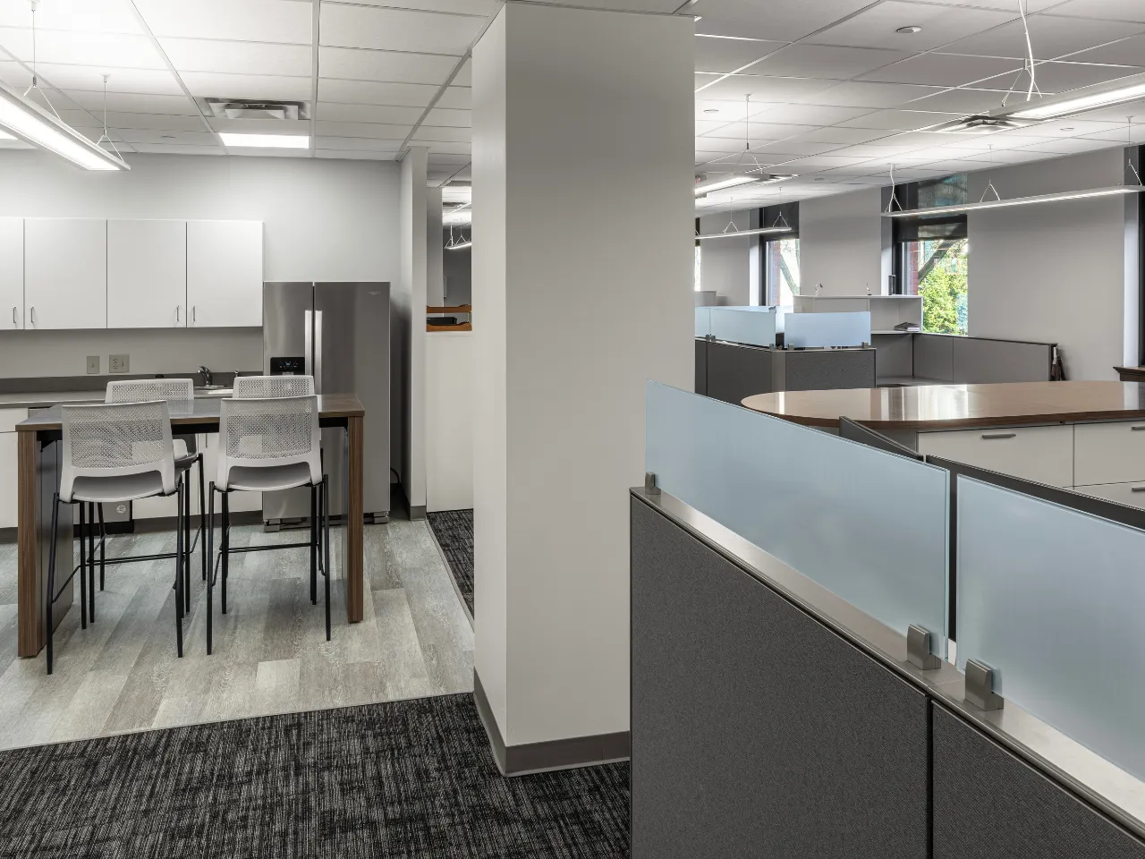 Contemporary open office space and kitchen adjacent area by Oswald Company.