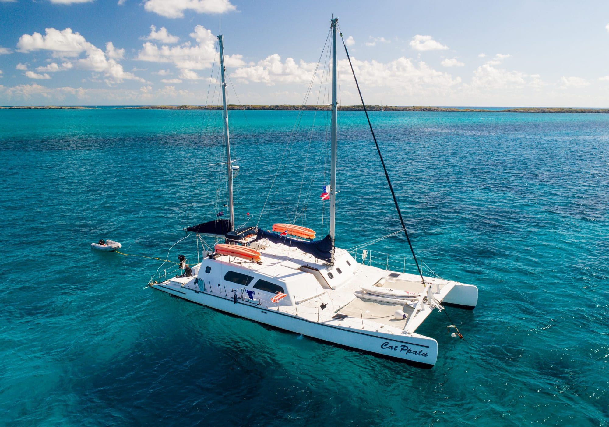 The Cat Ppalu catamaran under sail with its tender in tow, Bahamas