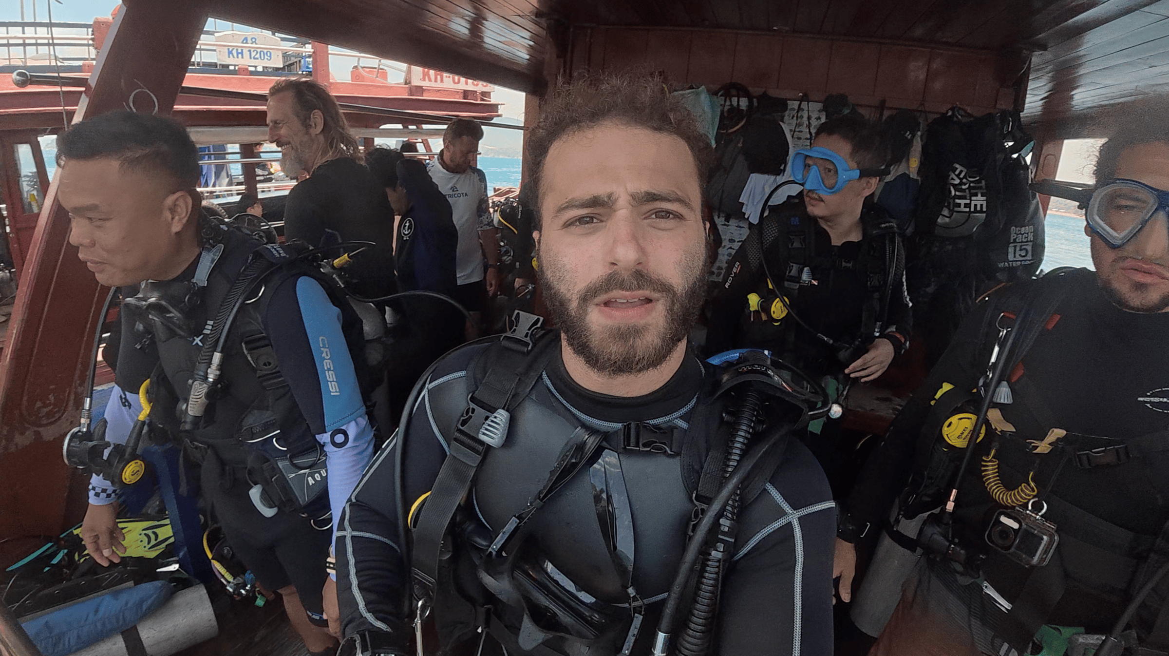 Austin geared up in scuba equipment on the dive boat with other divers at Dam Bay, Nha Trang, Vietnam