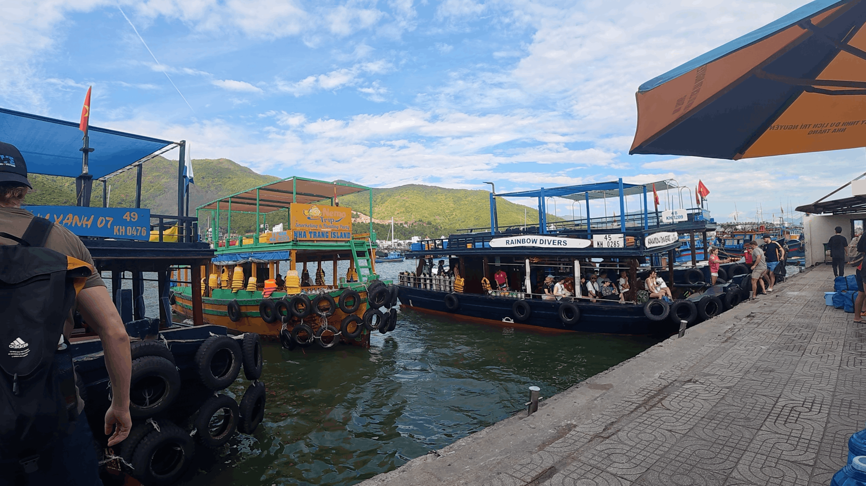 Wooden tourist and dive boats moored along the harbour pier before heading out at Dam Bay, Nha Trang, Vietnam