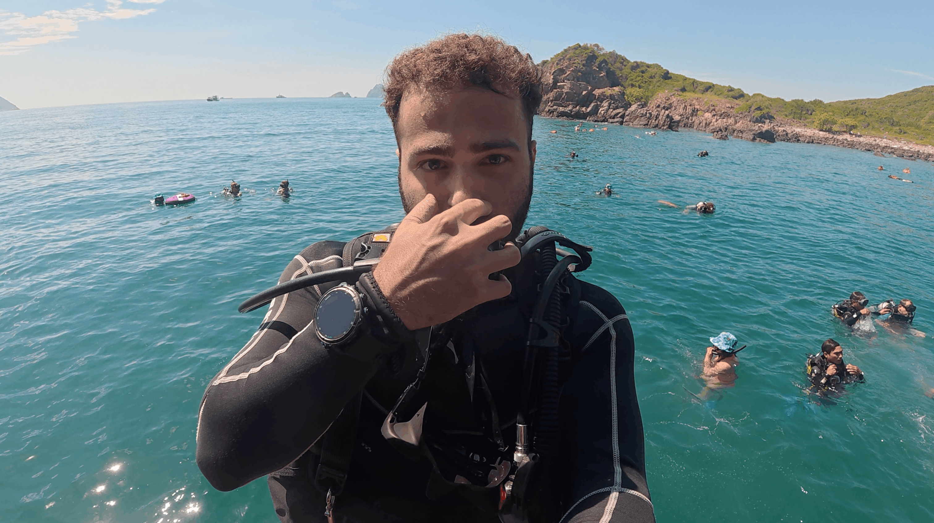 Austin at the surface in scuba gear with divers and snorkellers behind him at Dam Bay, Nha Trang, Vietnam