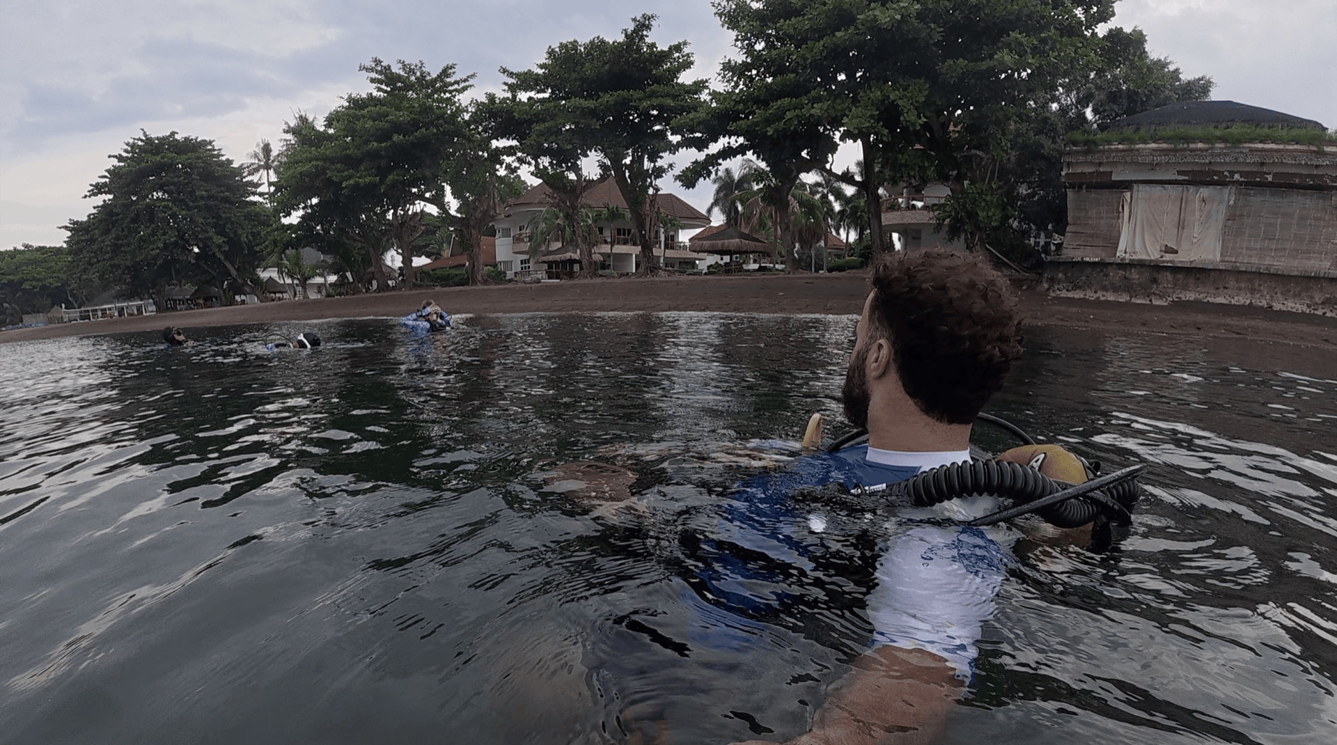 Divemaster Austin swimming out from the beach at El Dorado, Dauin, Philippines