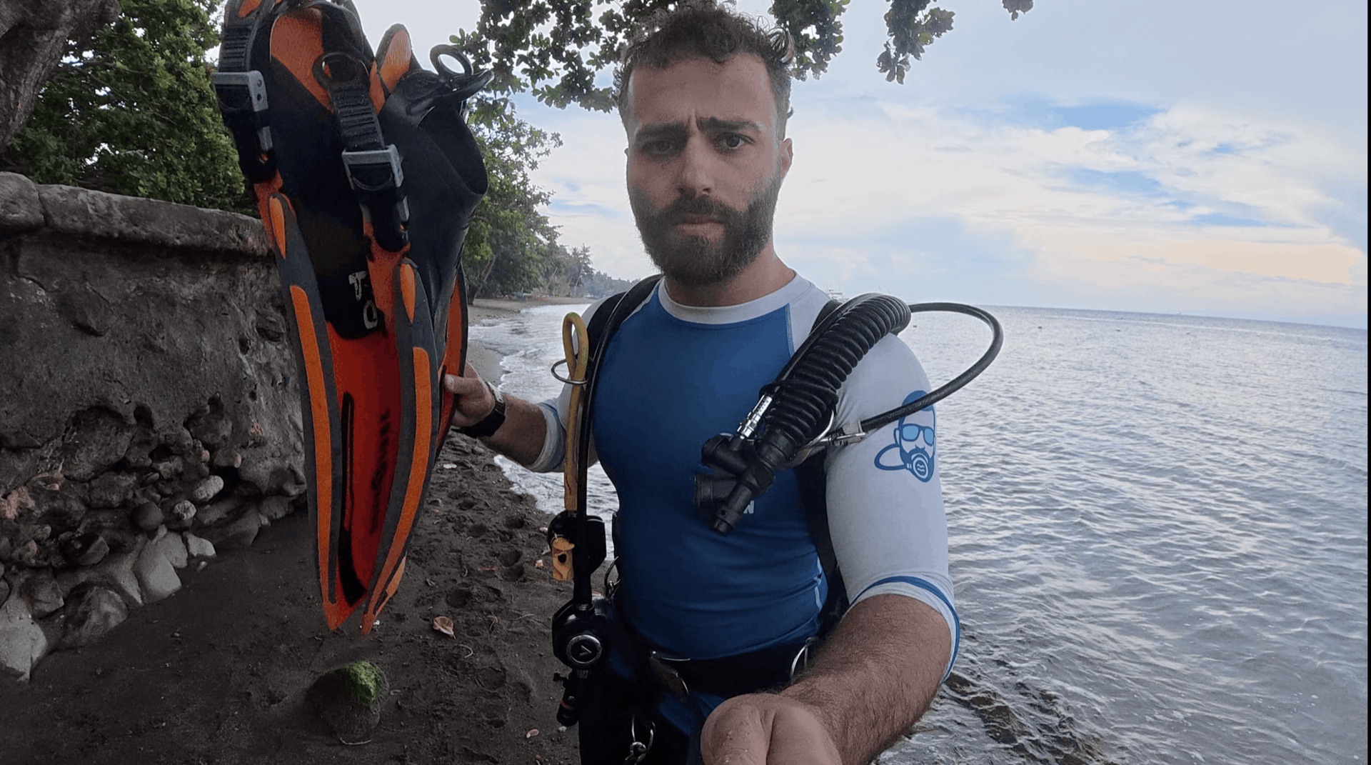 Divemaster Austin on the beach with his fins before the shore dive at El Dorado, Dauin, Philippines