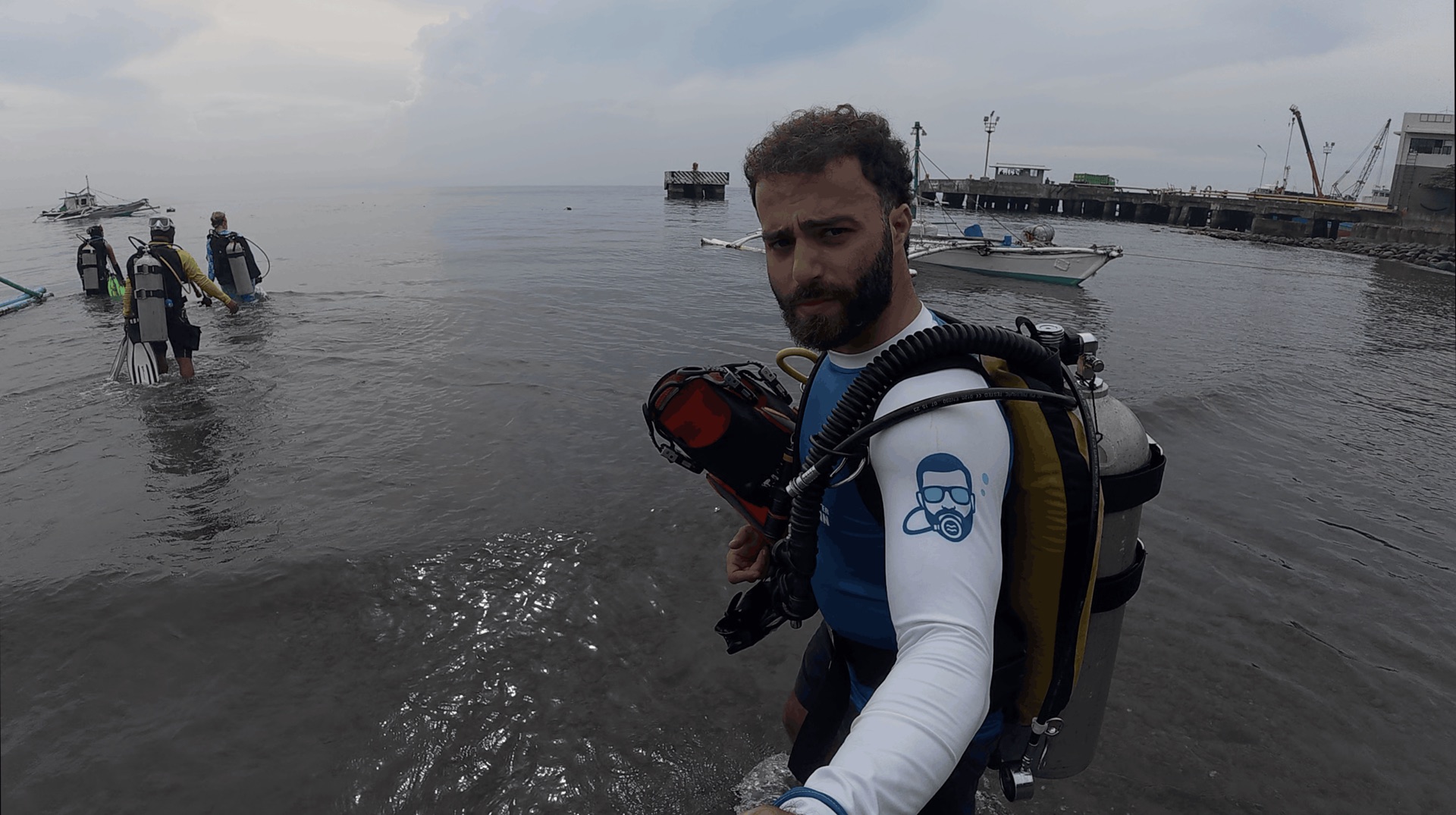 Divemaster Austin walking into the water for the shore dive at Dacumi, Dauin, Philippines