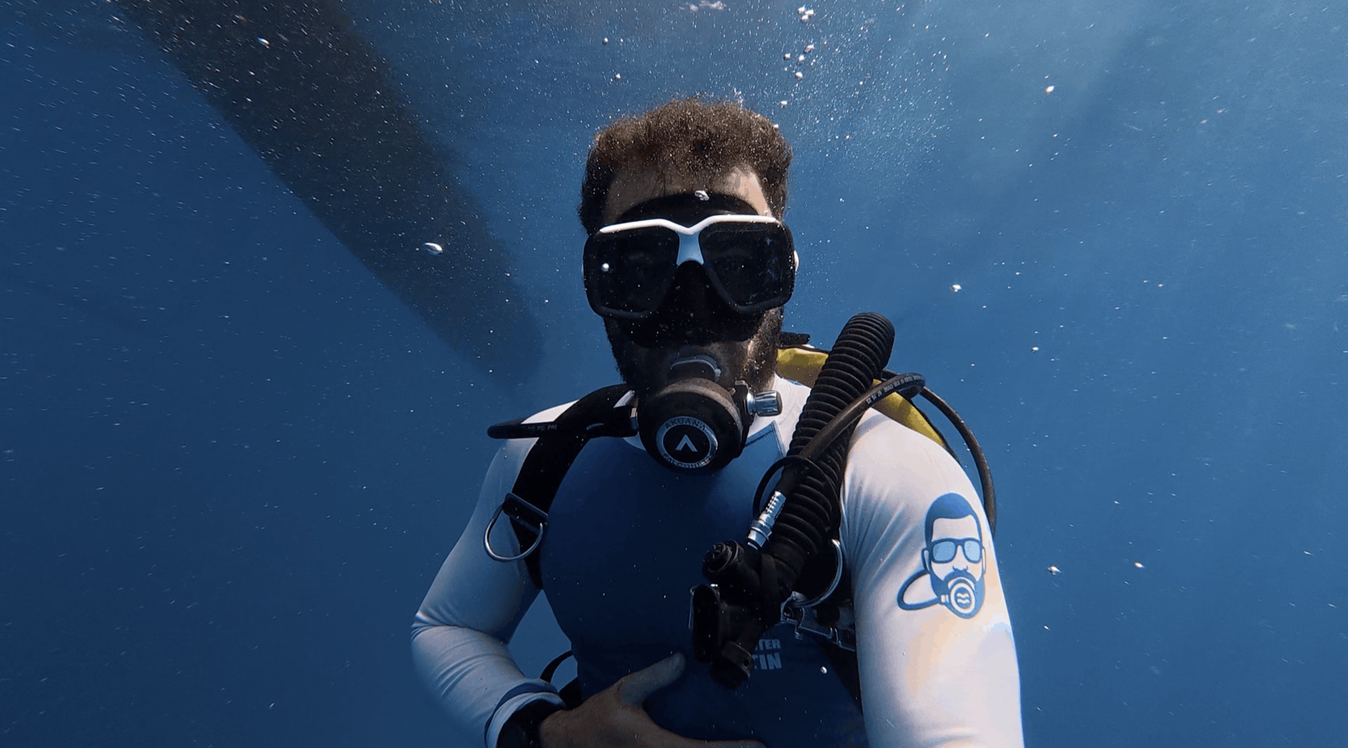 Divemaster Austin underwater below the dive boat at Chapel, Apo Island, Philippines