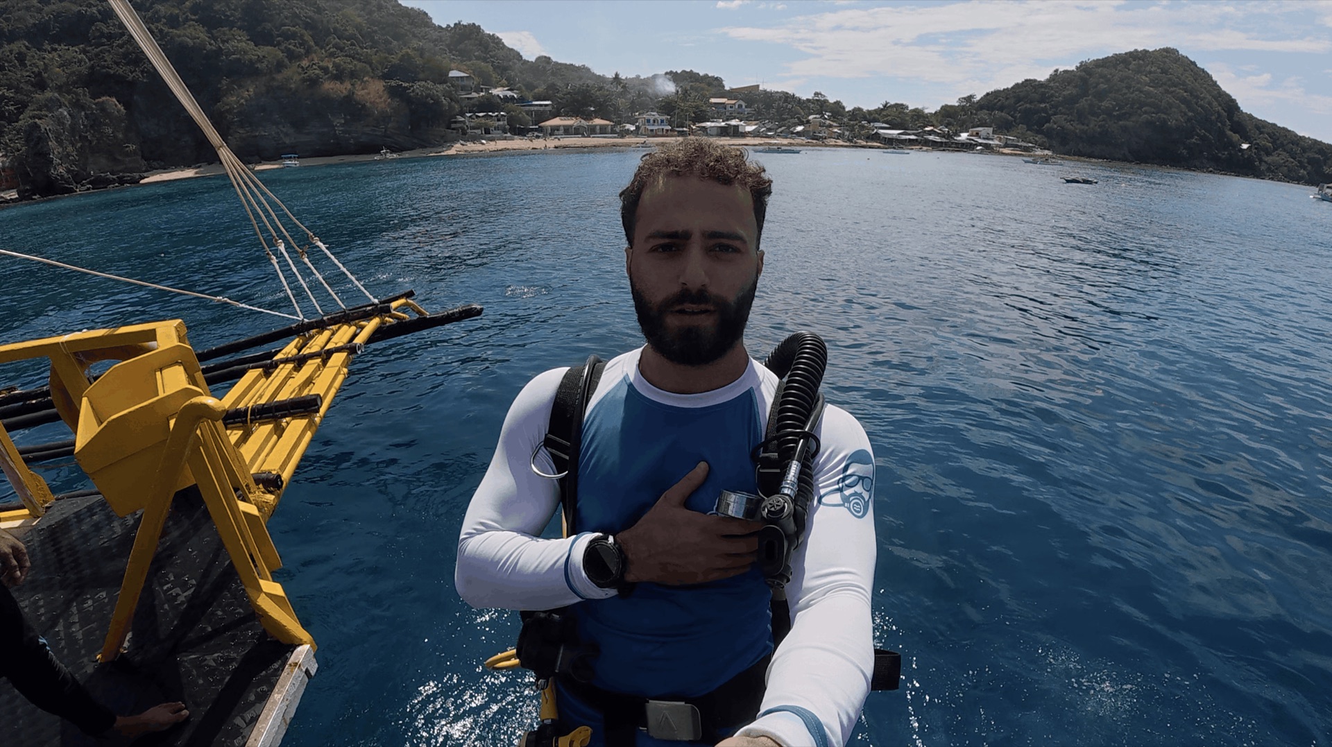 Divemaster Austin in a rash guard on the dive boat before the dive at Chapel, Apo Island, Philippines