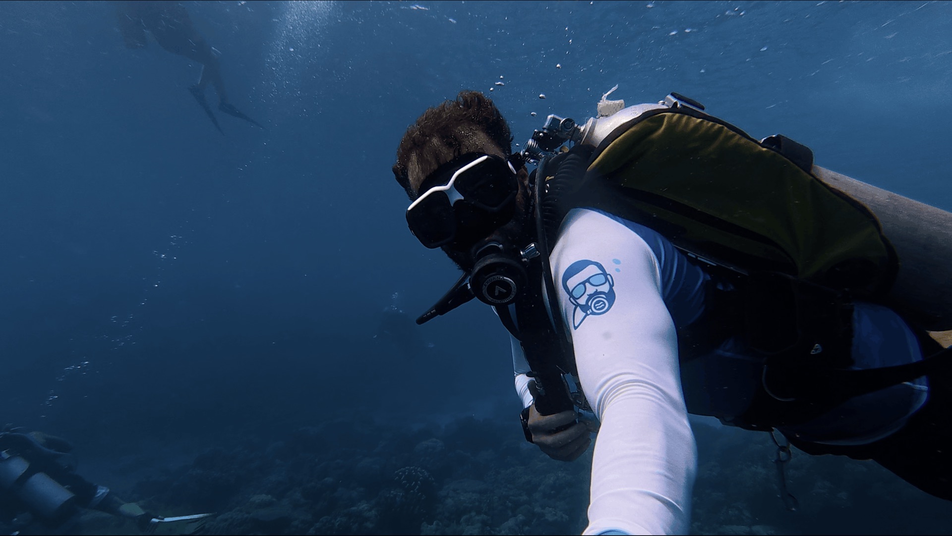 Divemaster Austin swimming down toward the reef at Largahan, Apo Island, Philippines