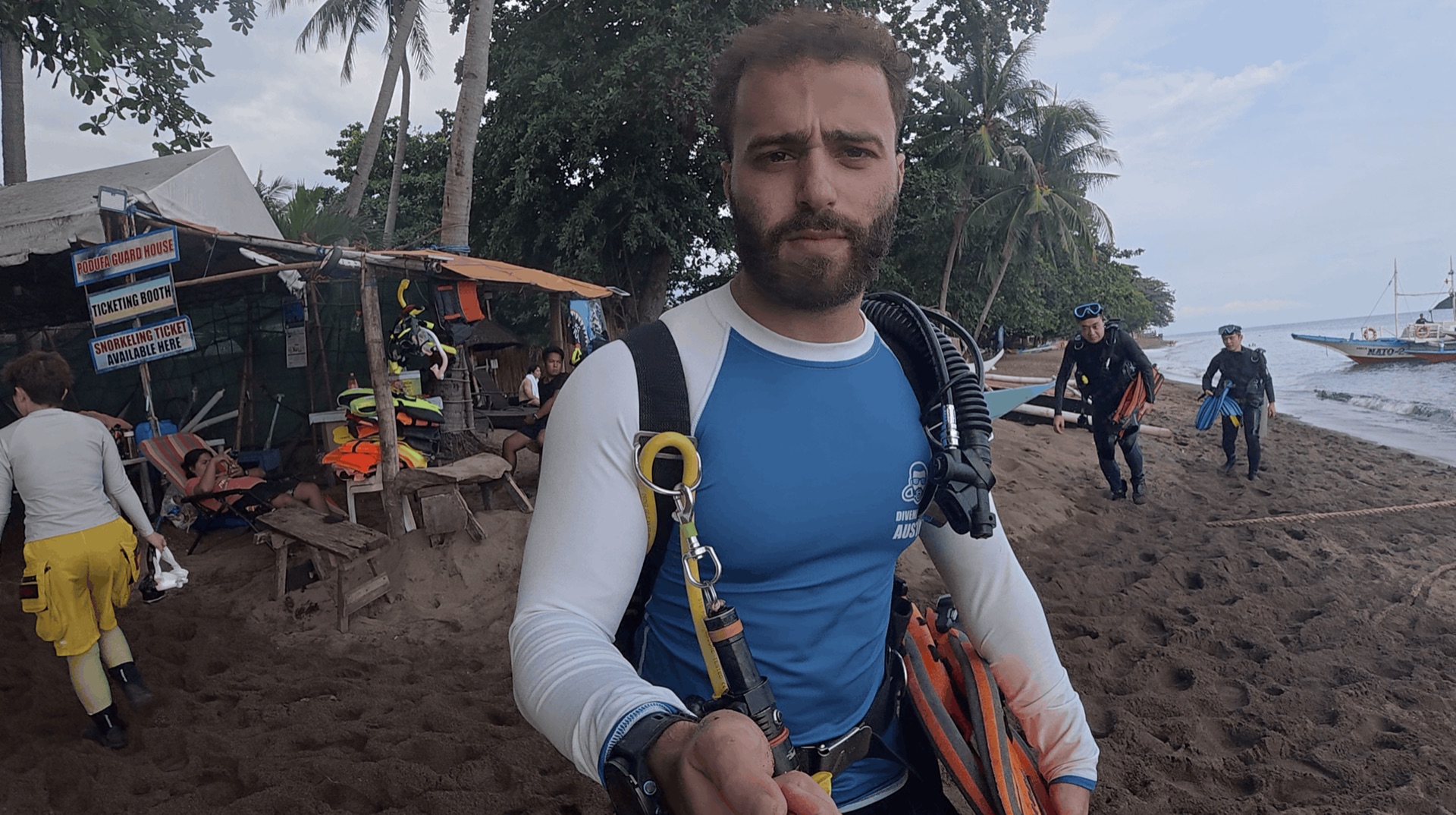 Divemaster Austin in his rash guard and gear on the beach before the shore dive at District One, Dauin, Philippines