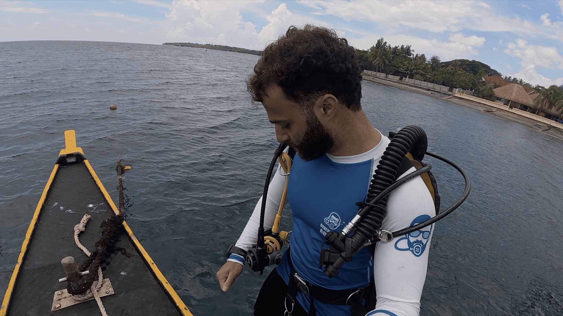Divemaster Austin in a rash guard on the bow of the dive boat before diving Thalatta, Zamboanguita, Philippines
