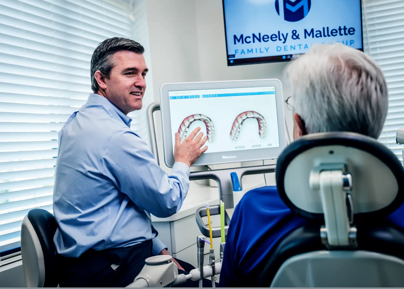 Dentist explaining digital dental impressions to a patient in a dental office.