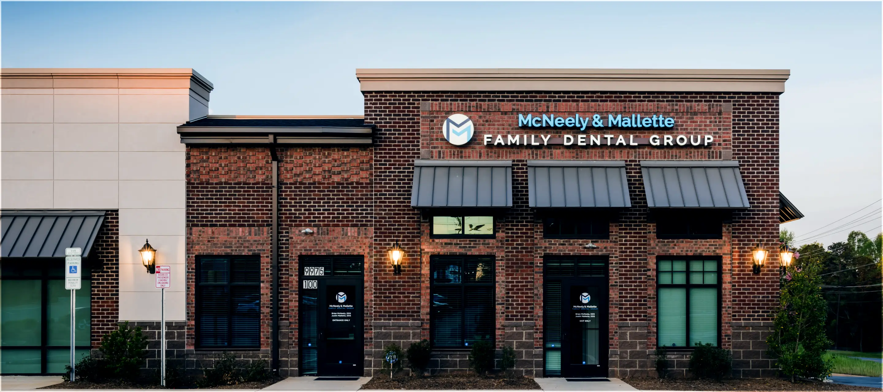 Brick building with sign 'McNeely & Mallette Family Dental Group' above two black entrance doors.