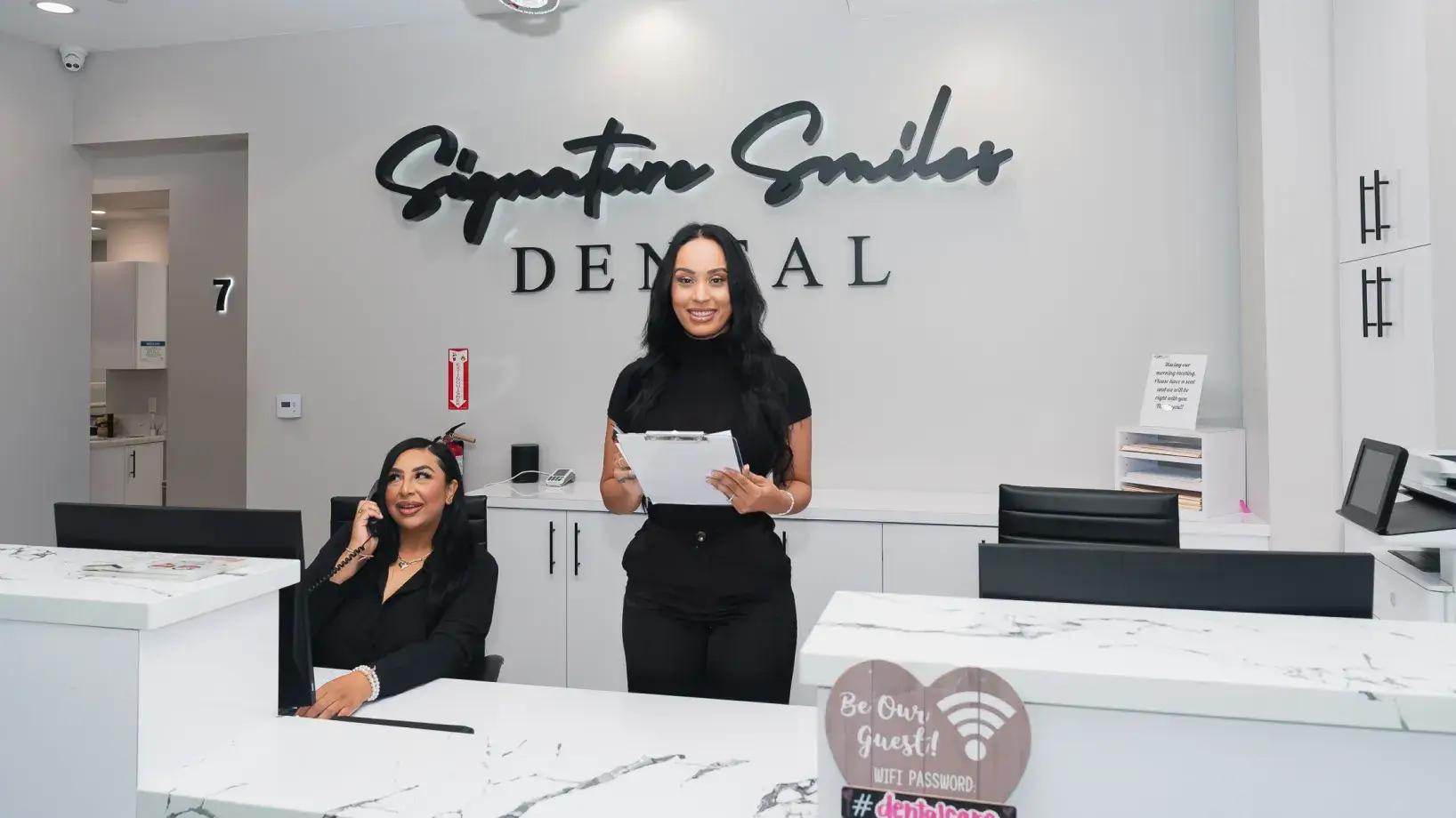 Two women standing in front of a dental office.