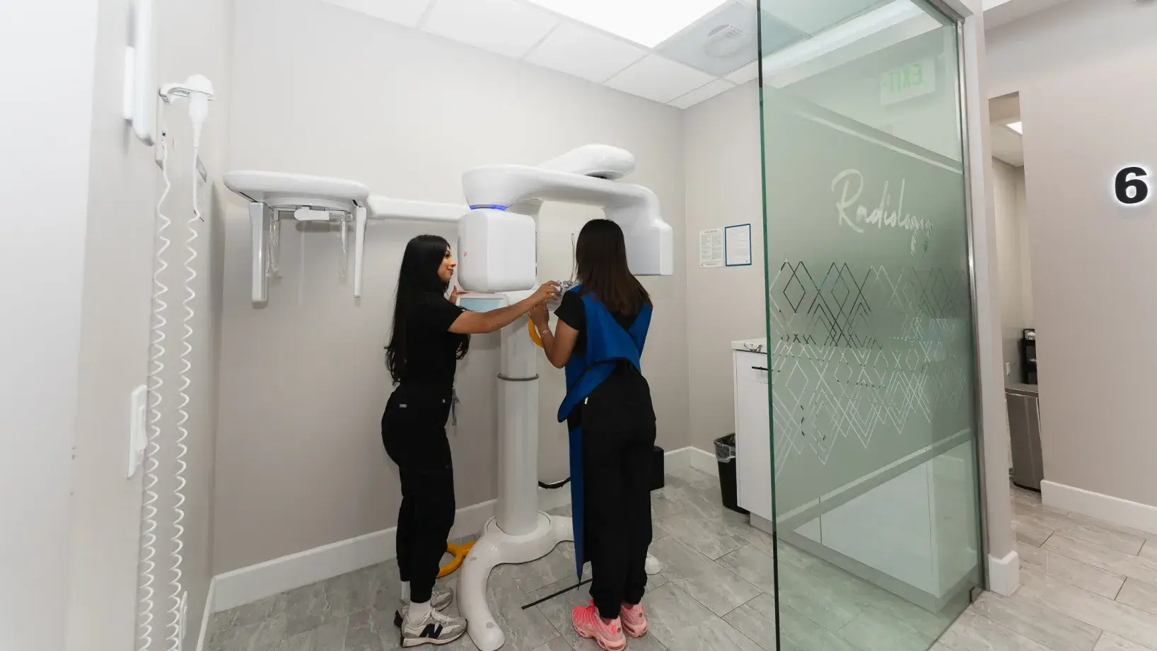 A couple of women standing next to each other in a bathroom.