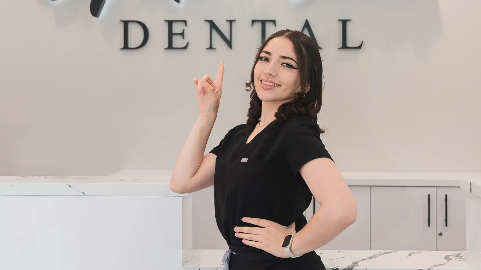 A woman standing in front of a dental sign.
