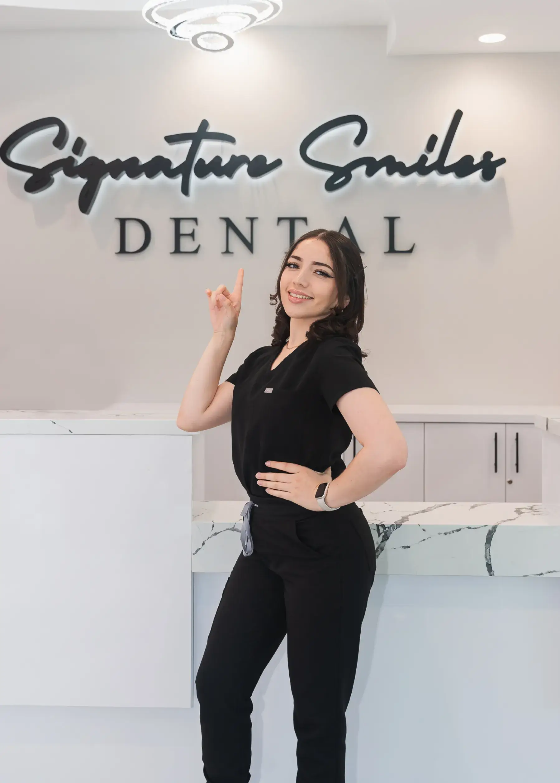 A woman standing in front of a dental sign.