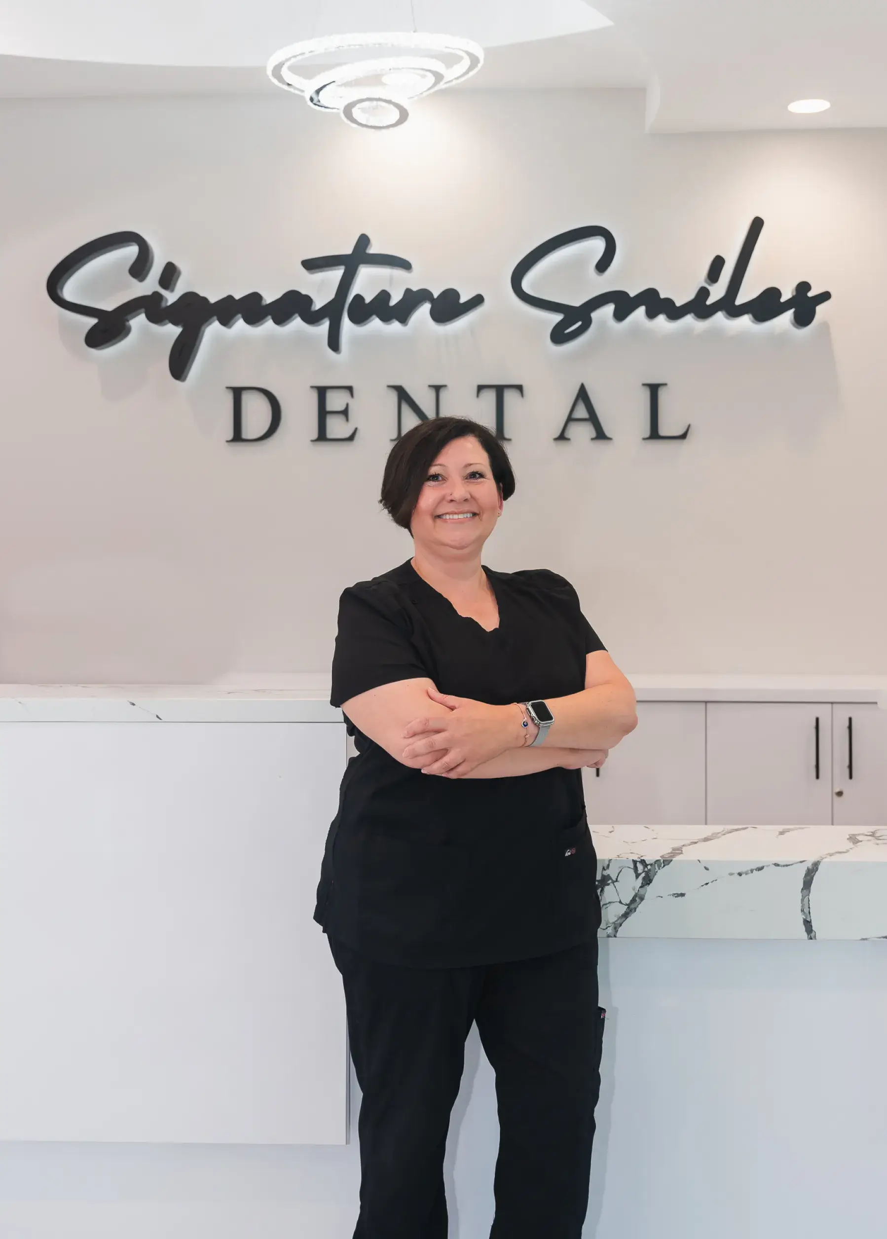 A woman standing in front of a dental sign.
