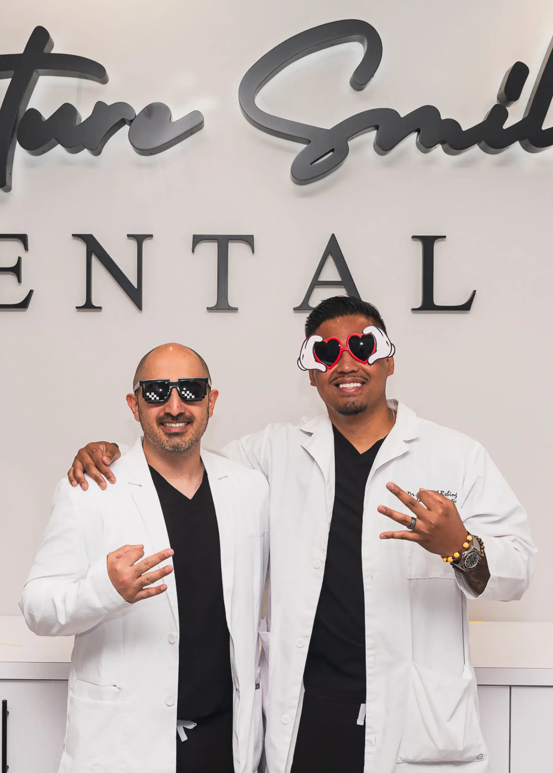 Two men standing next to each other in front of a sign.