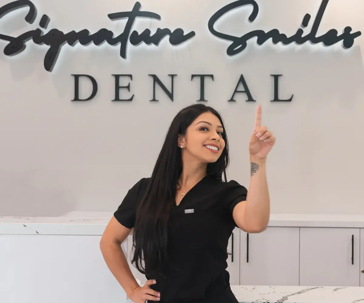 A woman standing in front of a dental sign.