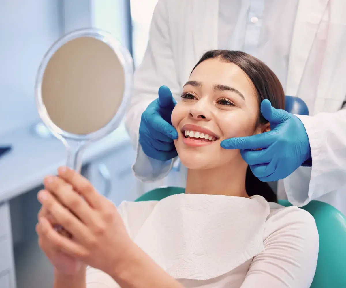 A woman sitting in a chair with a mirror in front of her.