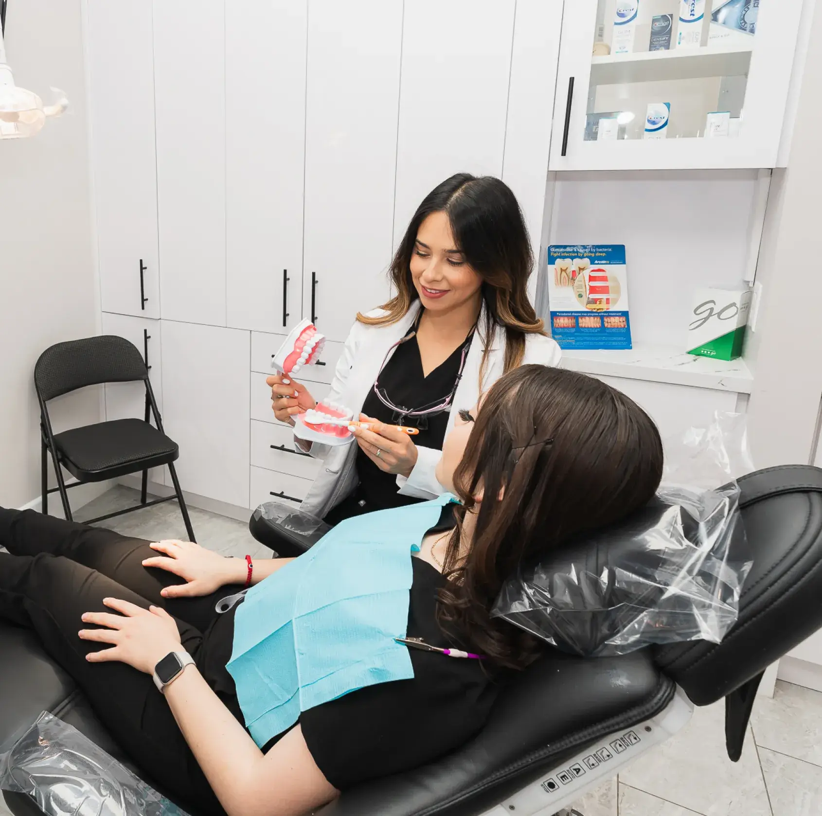 A woman sitting in a chair with another woman.