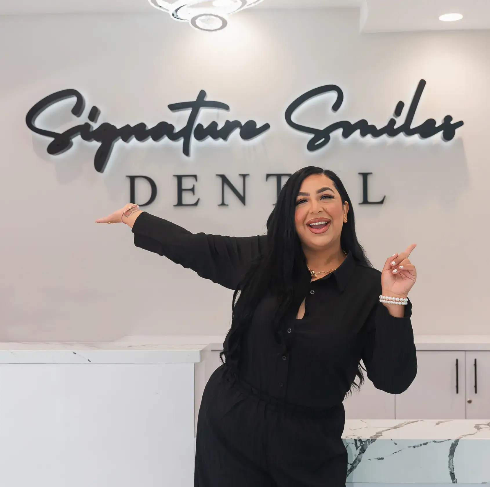 A woman standing in front of a dental sign.