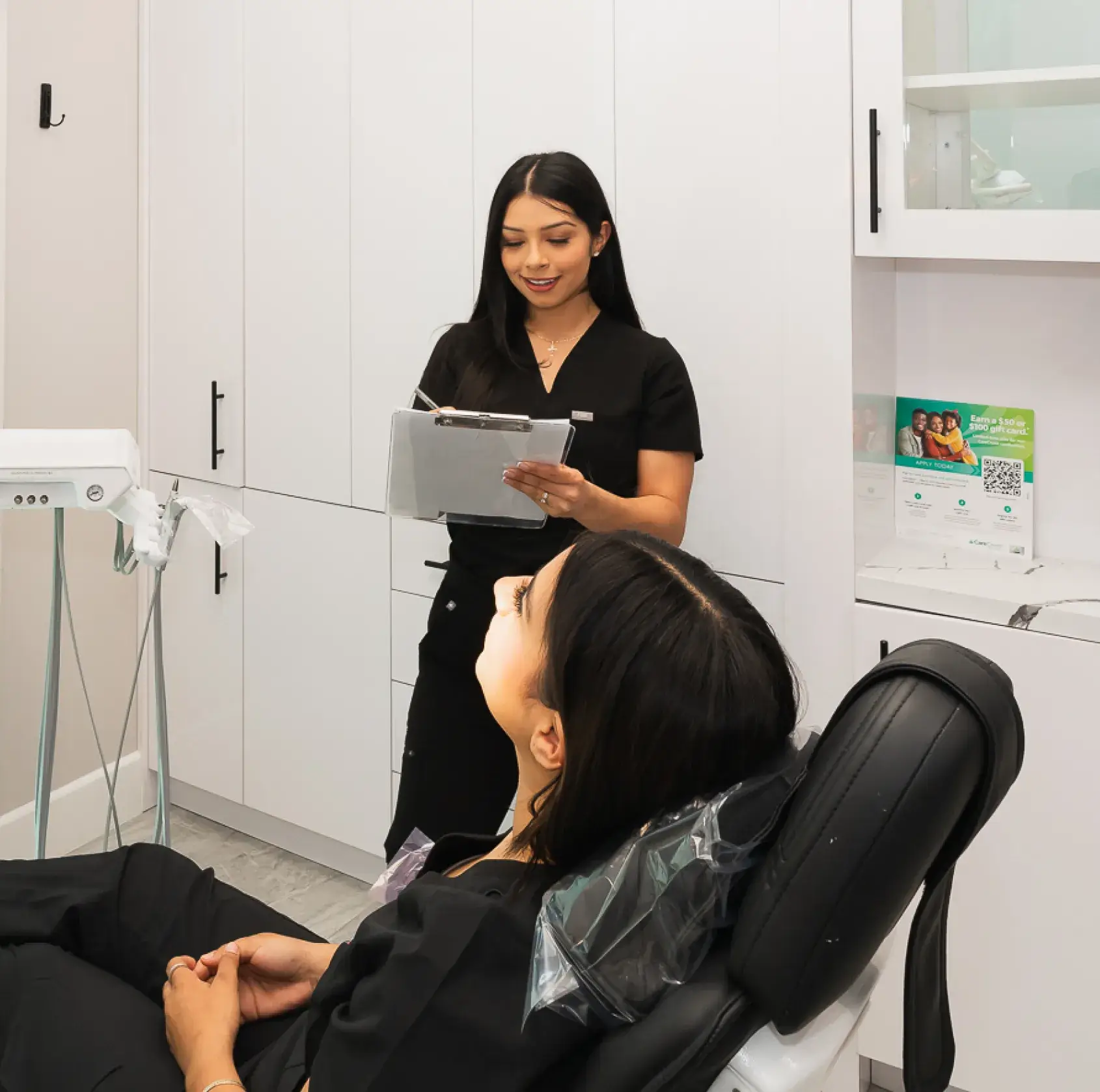 A woman sitting in a chair in a dental office.