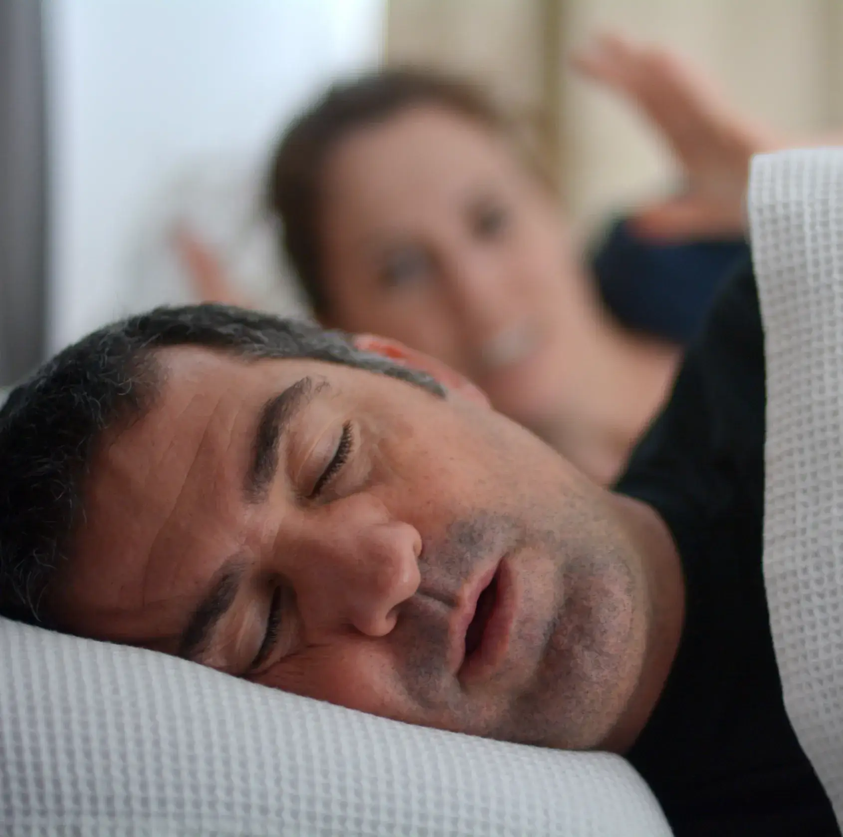 A man and a woman laying on a bed.