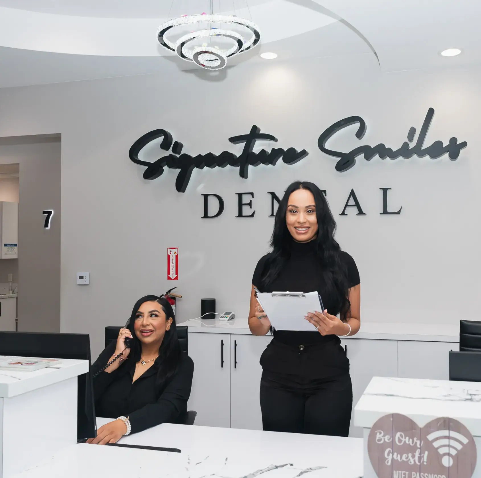 Two women standing in front of a dental office.