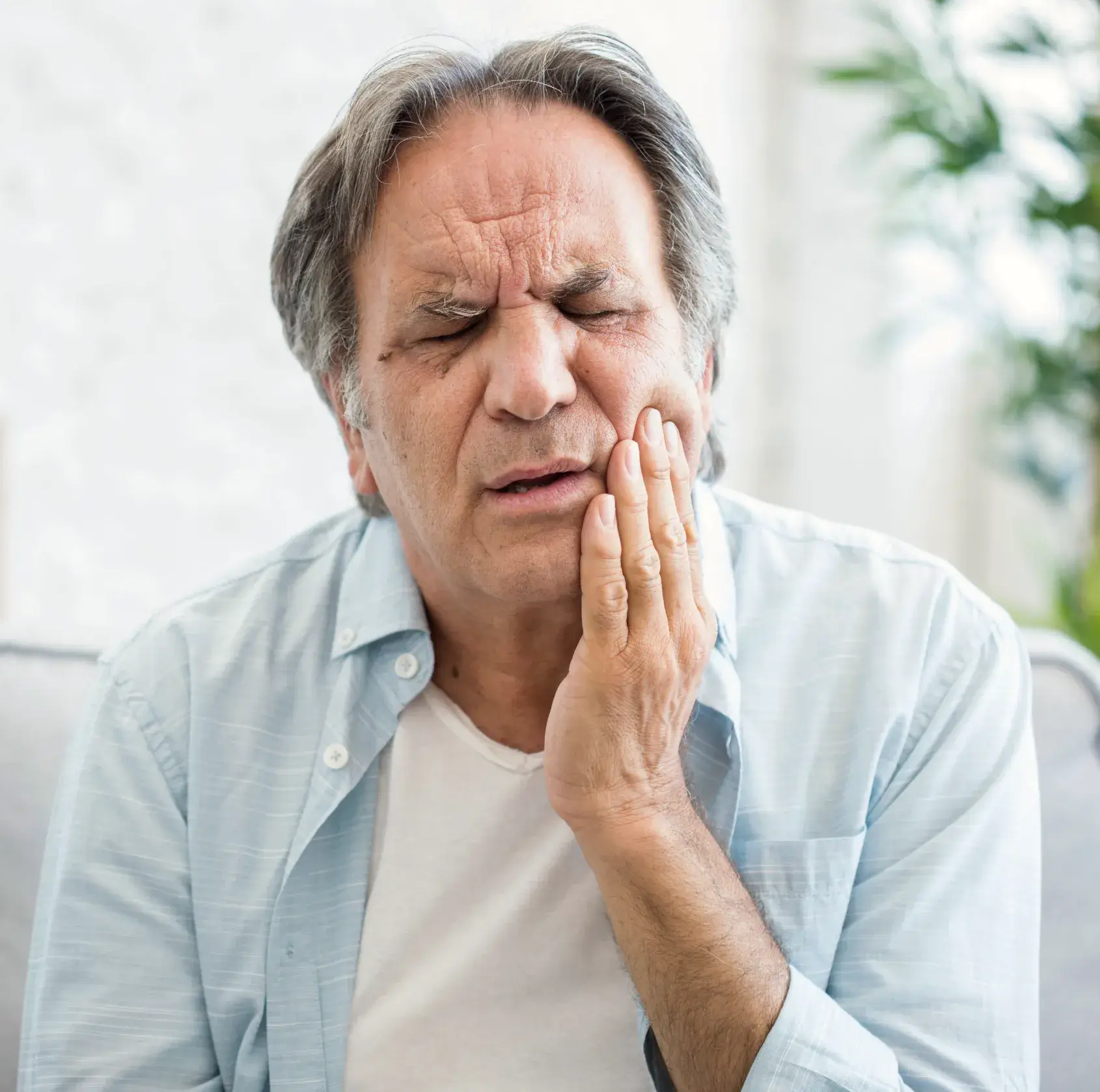 A man holding his hand to his face.
