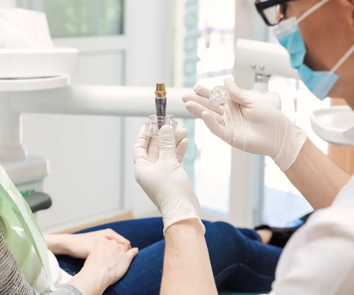 A person in a dentist's chair holding a small tube.