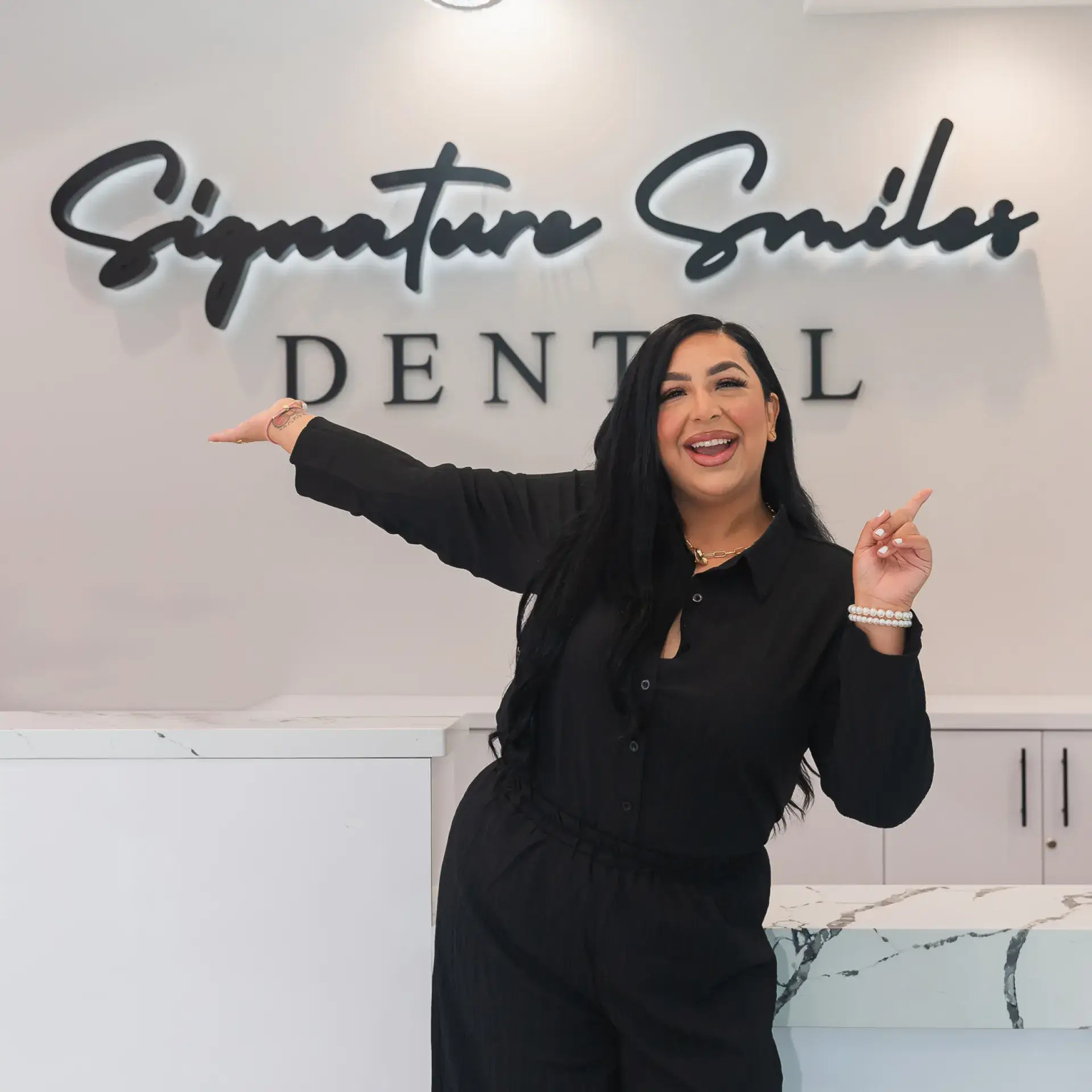 A woman standing in front of a dental sign.