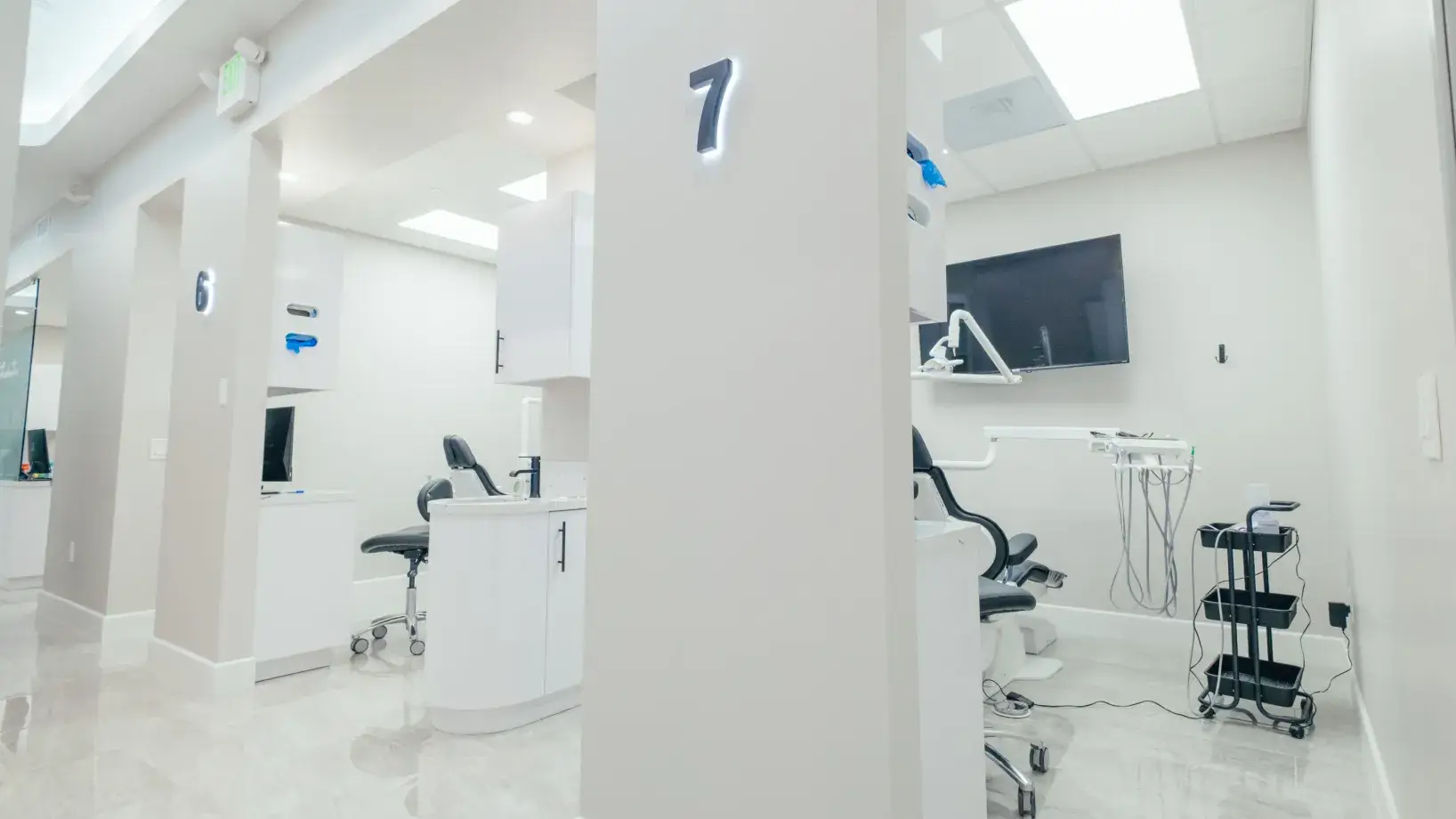 A white room with chairs and a television.
