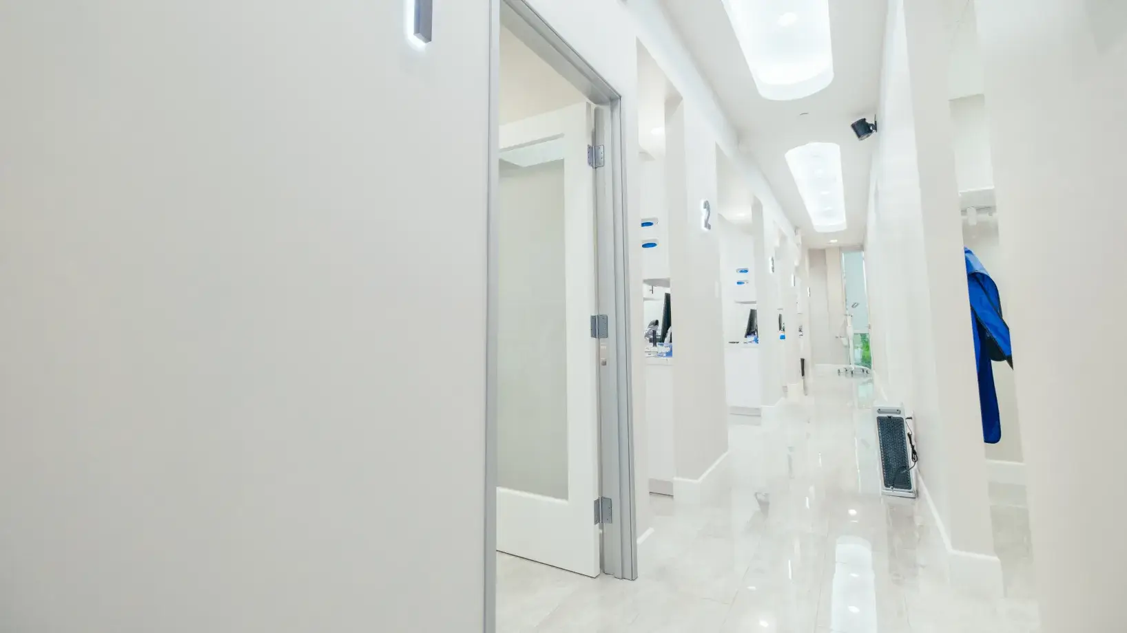 A long hallway with white walls and white floors.