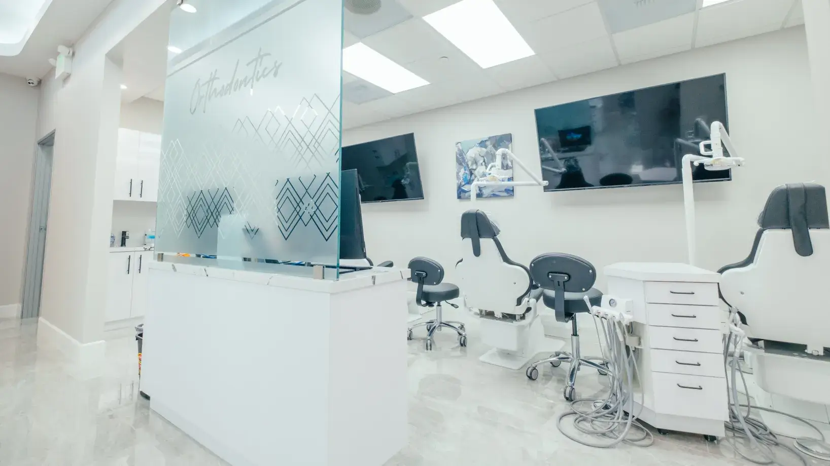 A white room with chairs and a television.