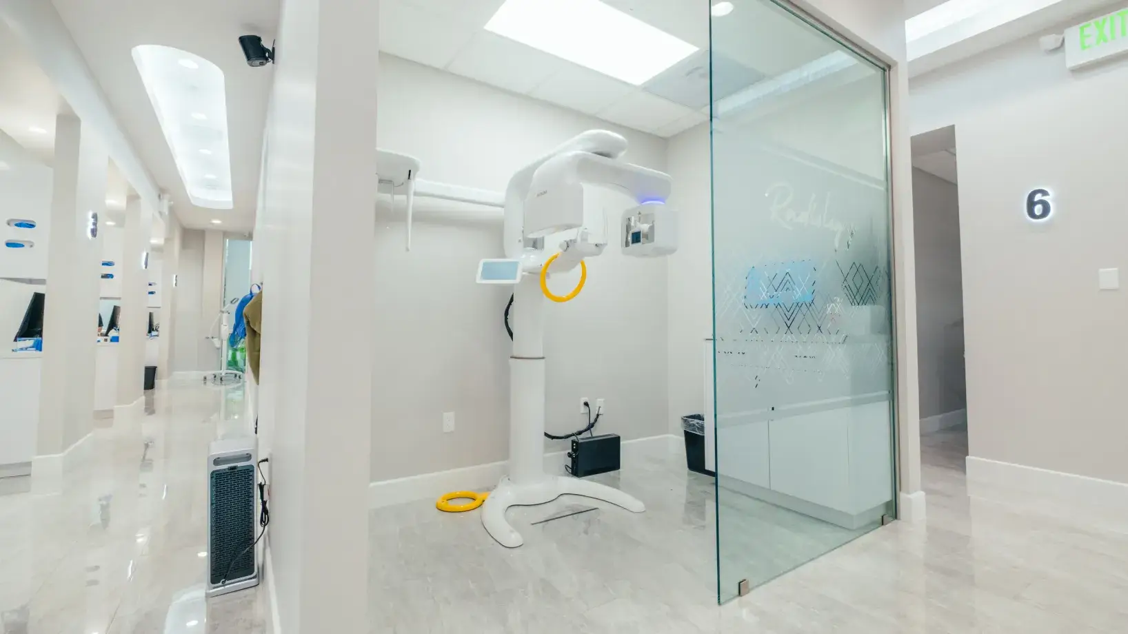A room with a glass door and a white and yellow device in it.