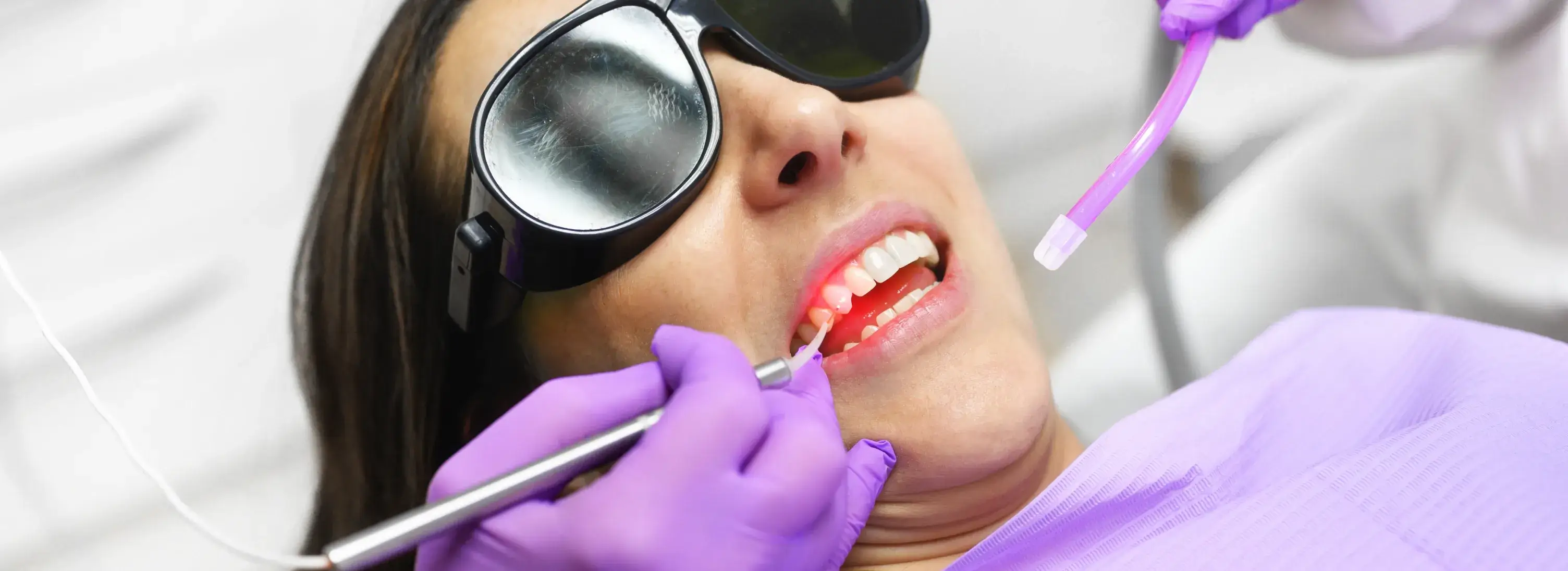 A woman getting her teeth checked by a dentist.