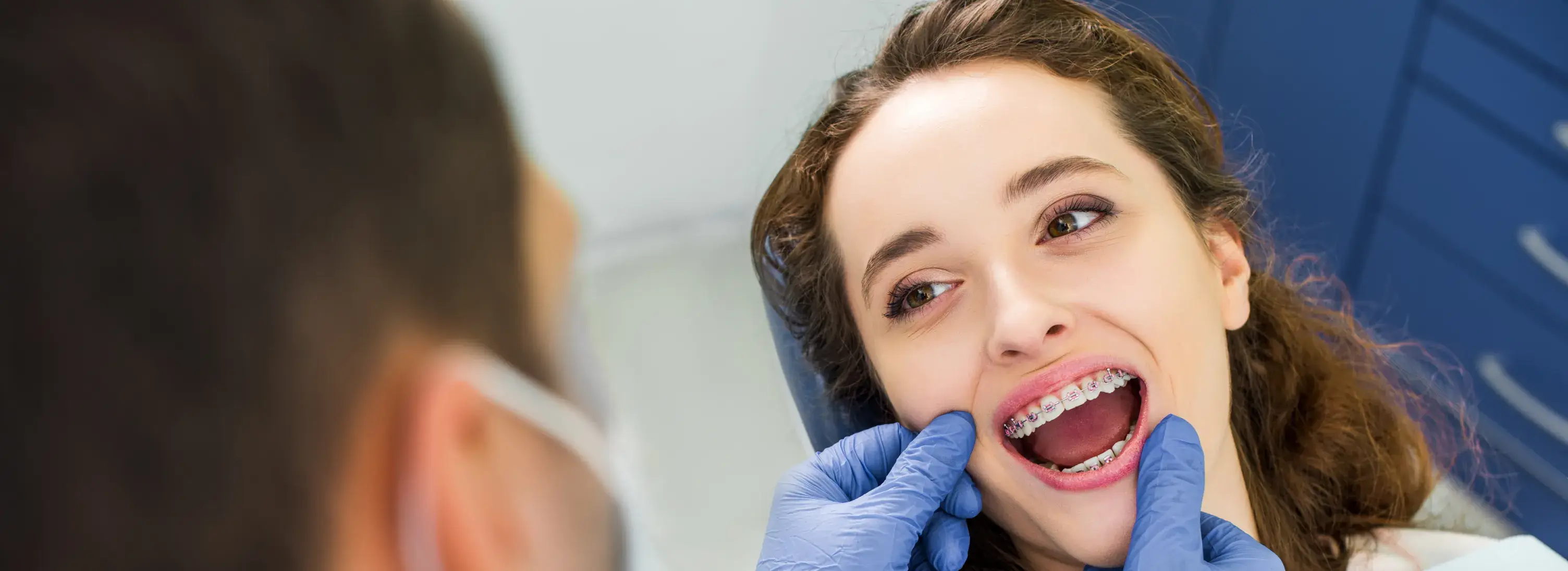 A woman getting her teeth checked by a dentist.