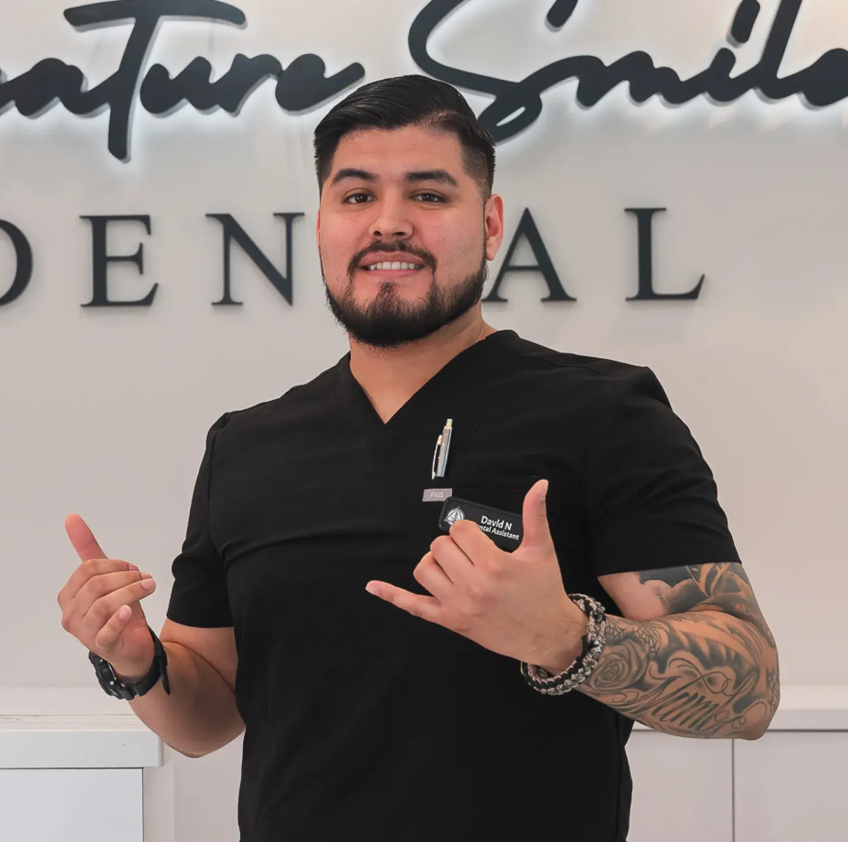 A man giving a thumbs up in front of a sign.