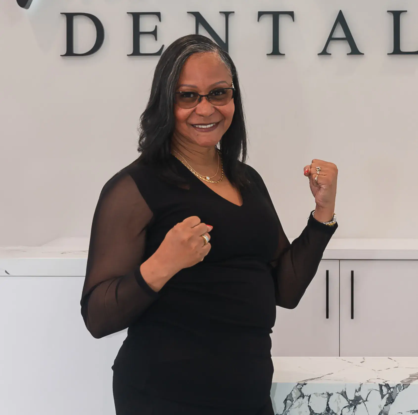 A woman standing in front of a dental sign.